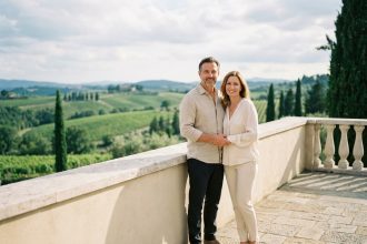 Couple souriant sur la terrasse d'une villa moderne avec vue panoramique